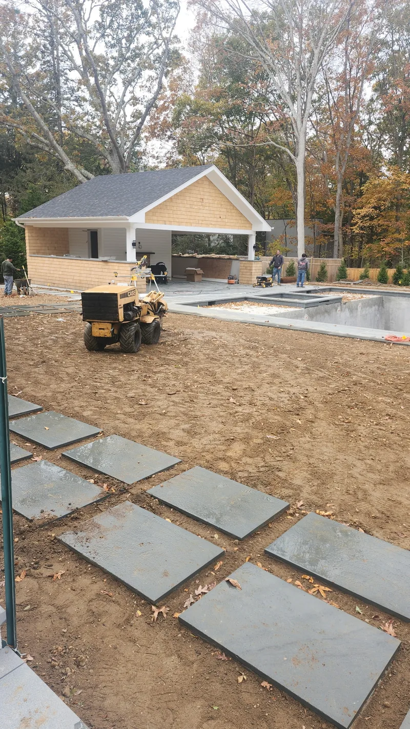 Graded soil beside a patio during a grading and irrigation project in the Hamptons.
